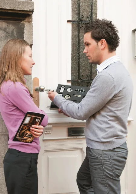 un homme et une femme discutent devant une habitation
