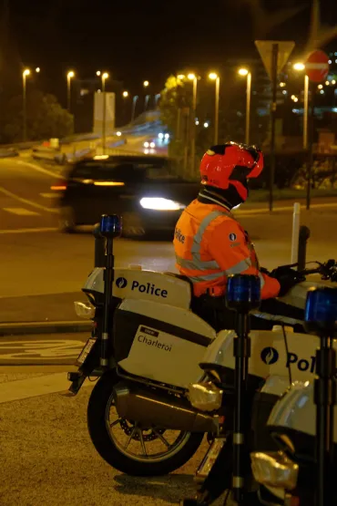 motard devant une voiture en image de fond
