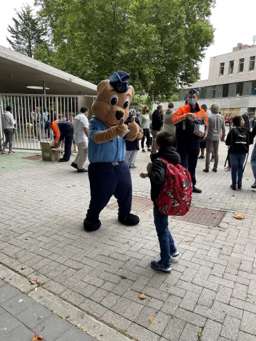 Mascotte check enfant devant école