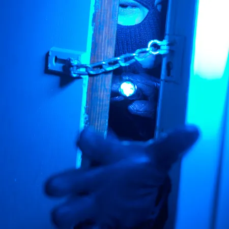inbreker steek hand door deur met hangslot