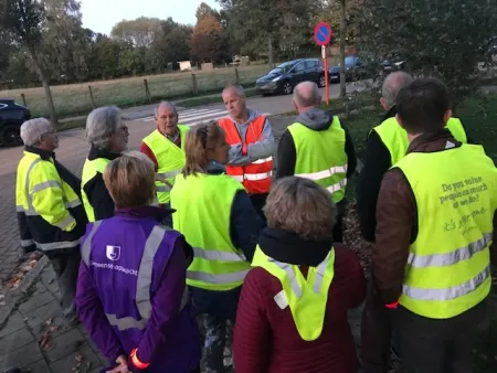 mensen met fluo hesje staan in kring te luisteren naar diefstalpreventieadviseur