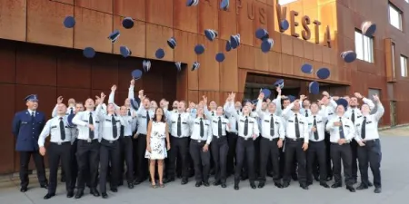 afgestudeerde politie-inspecteurs gooien hun kepie in de lucht