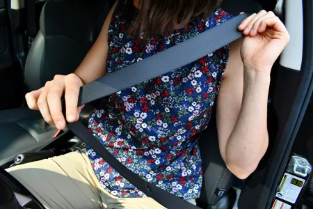 Chauffeur doet veiligheidsgordel vast in de auto