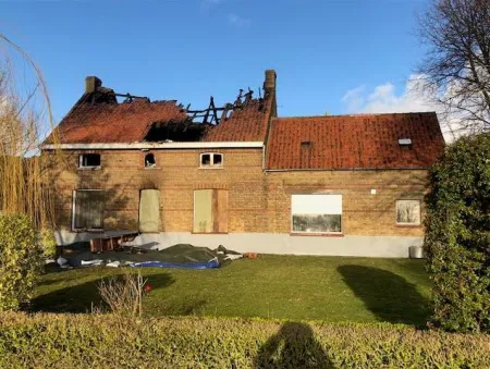 De woning waar de bliksem op insloeg, werd zwaar beschadigd door de ontstane brand.